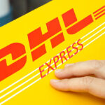 Tambov, Russian Federation - June 01, 2015: DHL Express package with human hand. Studio shot.