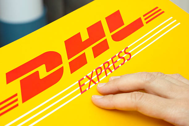 Tambov, Russian Federation - June 01, 2015: DHL Express package with human hand. Studio shot.